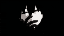 a black and white drawing of a person covering their face in the dark .