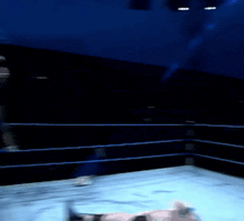a man in a skull and crossbones t-shirt stands in a wrestling ring
