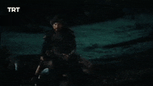 a man is riding on the back of a horse in front of a fire at night .