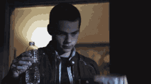 a man is holding a bottle of water and a bowl that says scott