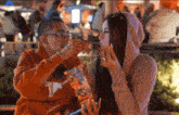 a man and a woman are eating popcorn and the man is wearing a hoodie with texas on it