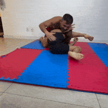 a man is wrestling another man on a mat