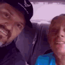 a man wearing a hat that says " for the force " smiles next to an older woman