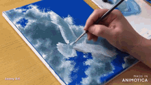 a person is painting a picture of a seagull on a blue canvas