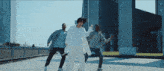 a group of people are dancing in front of a building that says llc on it