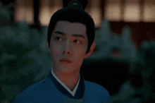 a man wearing a blue shirt and a black hat is looking up at something .