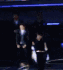 a man and a woman are dancing on a stage in the dark