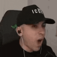 a man wearing a black hat and headphones is sitting in a chair .