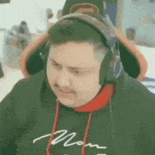 a man wearing headphones and a hoodie with the word mom on it