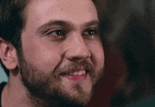 a close up of a man 's face with a beard