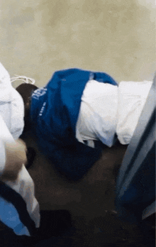 a person is laying on the floor with a blue shirt that says ' a ' on it .