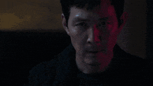a man in a suit and tie with blood on his face looks at the camera .