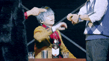 a man sitting at a table with a bottle of whiskey and two glasses of whiskey