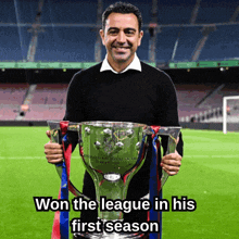 a man holding a trophy that says ' won the league in his first season '