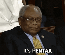 a man in a suit and tie is saying " it 's pentax "