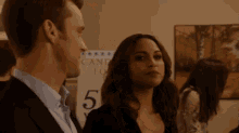 a man and a woman are standing next to each other and looking at each other .