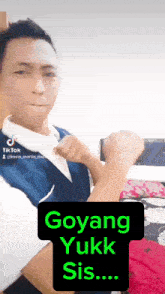 a man with his fist in the air and a sign that says goyang yukk sis..