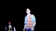 a man in a striped shirt says " the world can 't stop us " on a screen
