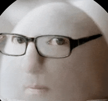 a close up of a person 's face with glasses .