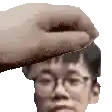 a hand is touching a man 's forehead with glasses on .