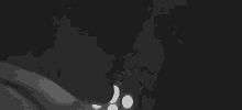 a black and white photo of a man and a woman kissing in the dark .