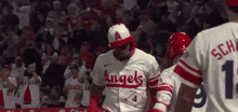 a baseball player wearing a angels jersey is walking on the field