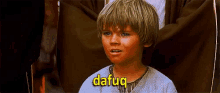 a young boy with the word dafaq on his shirt .