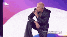 a man singing into a microphone with the word hito on the top