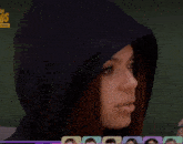 a woman wearing a black hooded sweatshirt is sitting next to a teddy bear