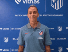 a woman stands in front of a blue wall that says viths