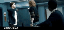 a man and a woman are standing next to each other in a room with the hashtag #bitchslap