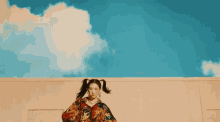 a woman with pigtails is wearing a colorful shirt