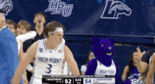a man in a high point jersey stands next to a mascot