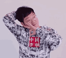 a man wearing glasses and a hoodie with chinese characters on it