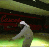 a person dancing in front of a cascade sign