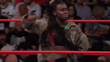 a wrestler stands in a wrestling ring with a scoreboard behind him that says primetime