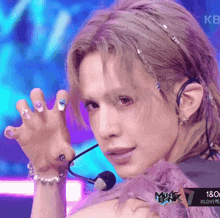 a close up of a person 's face with a music bank logo in the bottom right corner