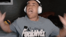 a man wearing headphones and a t-shirt that says " fuckmvx " is making a funny face .