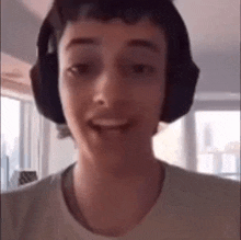 a close up of a person wearing headphones and a t-shirt .