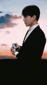 a man in a suit and tie holds a cell phone