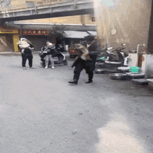 a group of people are walking down a street in front of a store that has chinese writing on it