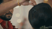 a man with a beard is putting a ring on a woman 's head .