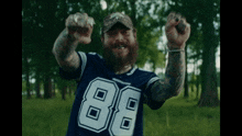 a man with a beard is wearing a cowboys jersey with the number 88 on it
