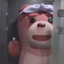 a pink teddy bear wearing a towel on its head