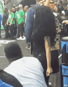 a man in a white shirt is kneeling down in front of a trash can that says pc
