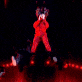 a woman in a red outfit is singing on a stage