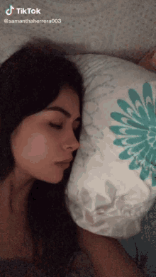 a woman is sleeping in a bed with a pillow that says tiktok on it