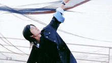 a man in a blue jacket is reaching up into the sky