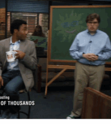 two men are standing in front of a chalkboard with the words " a few of thousands " on the bottom
