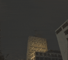 a large fire is coming out of a building at night .